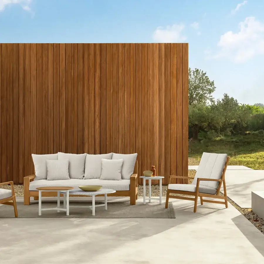 Distinguished Talenti Oliver lounge chair with enveloping white cushions and light tan teak frame showcasing a minimalist slatted backrest