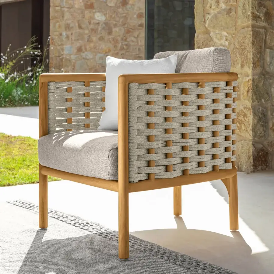 Elegant Talenti Prichi lounge chair with light tan teak structure and intricately woven textile panels with a bright white seat cushion