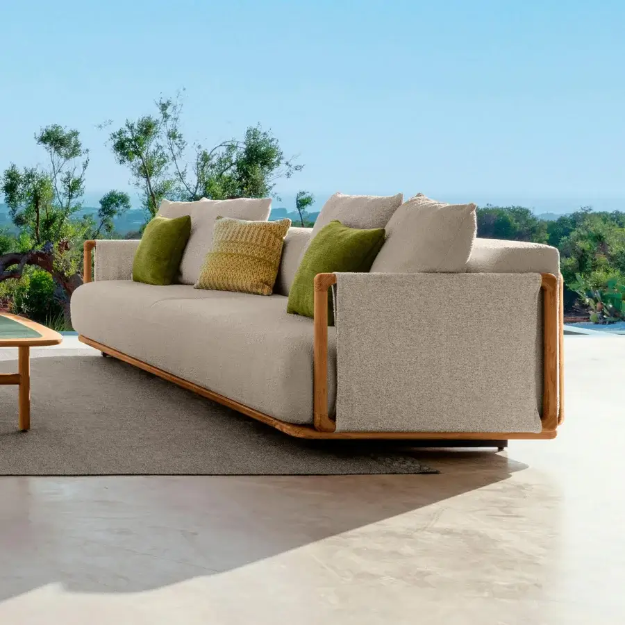 Elegant Talenti Jun sofa with light beige textile upholstery and a visible teak structure crafted with dark green and yellow pillows