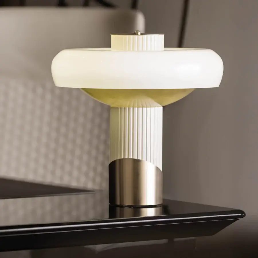 Exceptional Turri Claire table lamp with cream metal and brushed gold details emitting warm bronze light