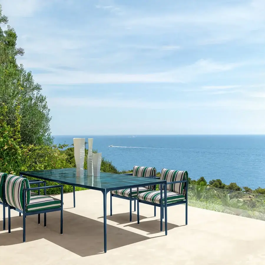 Elegant Talenti Nalu table with sleek deep teal metal frame and smooth glass tabletop crafted in Italy