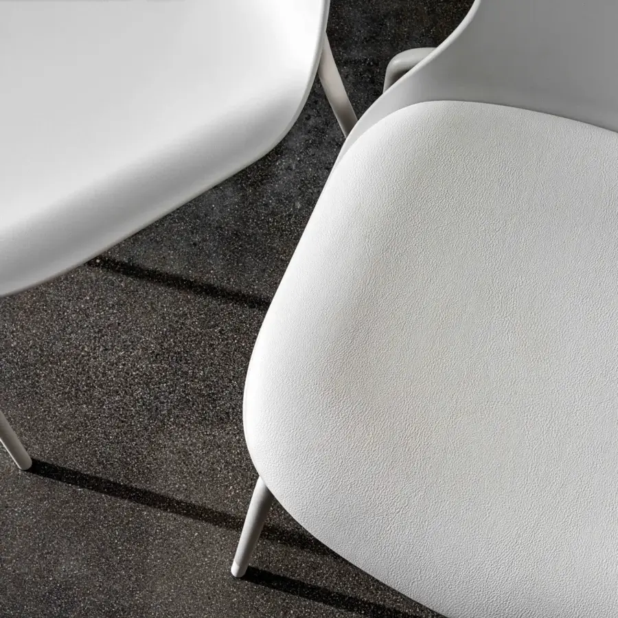 Distinguished Sovet Italia Olly chair with clean curved lines and a textured seat upholstered in bright white synthetic material or leather with matte legs