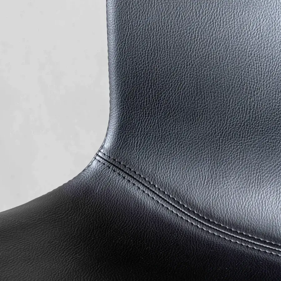 Refined Sovet Italia Olly chair in textured black synthetic material highlighted with double stitched seams