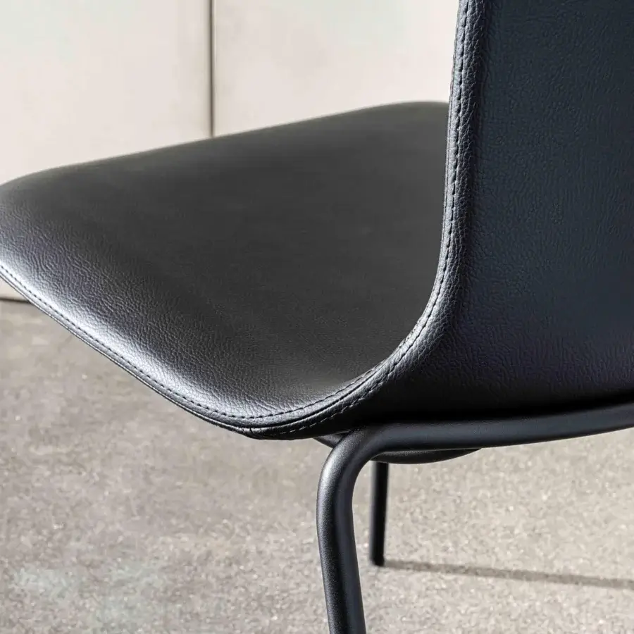 Distinguished Sovet Italia Olly chair with sleek black synthetic upholstery and minimalist matte black metal legs
