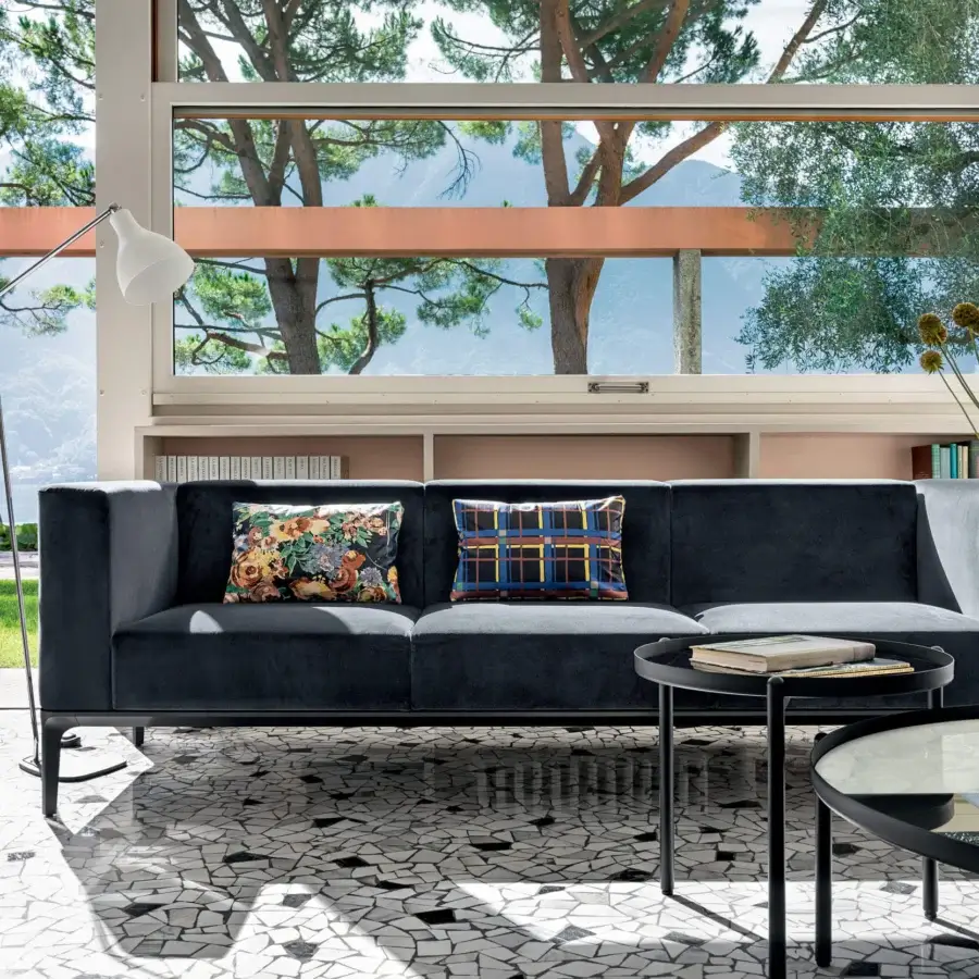 Distinguished Sovet Italia Slim sofa with dark textile upholstery and die-cast aluminum legs complemented by floral and plaid cushions