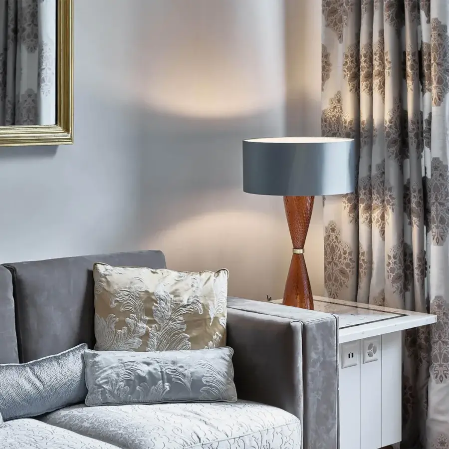 Distinguished Italamp Cheers table lamp with textured glass base and gold metal accent topped with a grey conical fabric lampshade