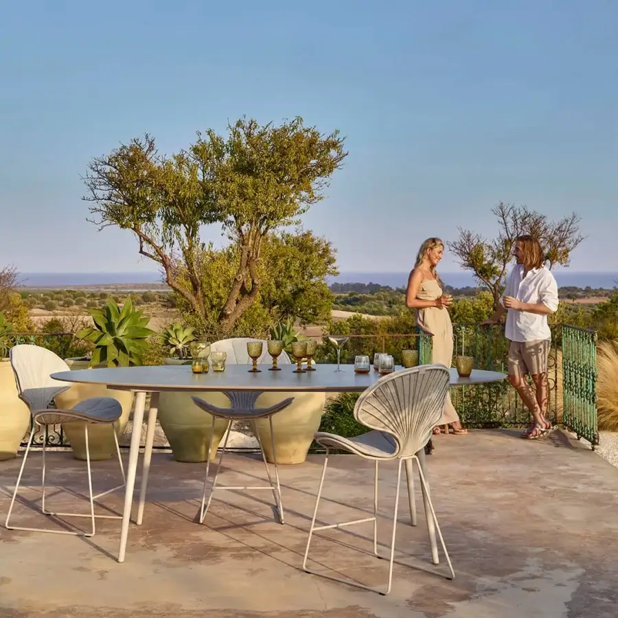 Elegant Royal Botania Styletto table stool with oval teak wood top and light grey woven material in matte white coated aluminum