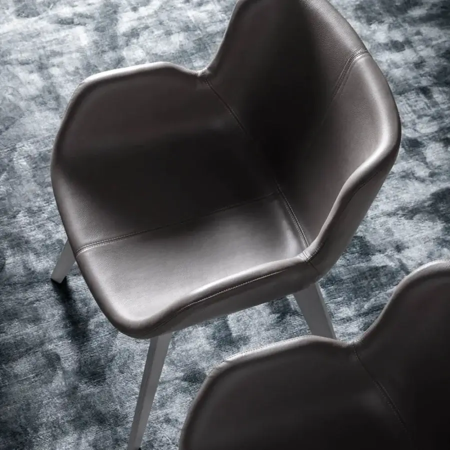 Exclusive OAK Nota armchair with rounded form, smooth dark leather upholstery and painted ash wood base