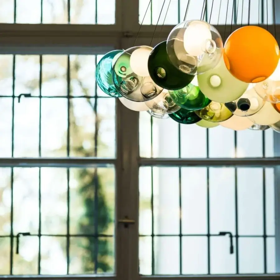 Captivating Bocci 28 Cluster suspension lamp with clear glass exterior and milk white interior lamp holder cavities suspended by dark metal cables