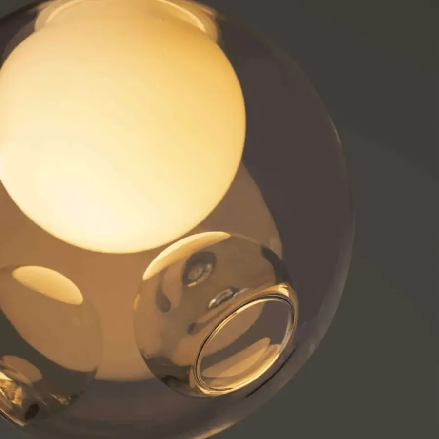 Distinguished Bocci 28 single suspension lamp crafted in clear glass with a warm amber tone and milk white interior