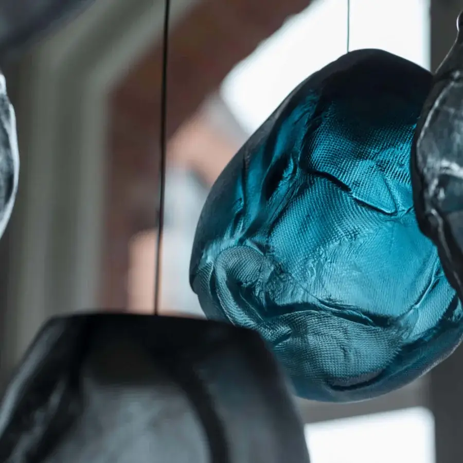 Captivating Bocci 73V suspension lamp with folded glass shade in muted teal and blue-green hues with a matte textured finish