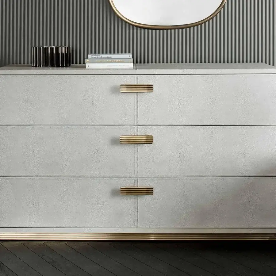 Exclusive Rugiano Club dresser crafted in light gray leather with brushed brass handles and matching base band