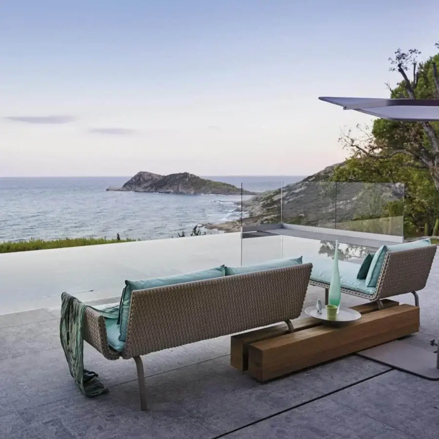 Distinguished Roberti Rattan Key West lounger built with powder-coated aluminum and Sunrope in light brown tones with light blue textile cushions
