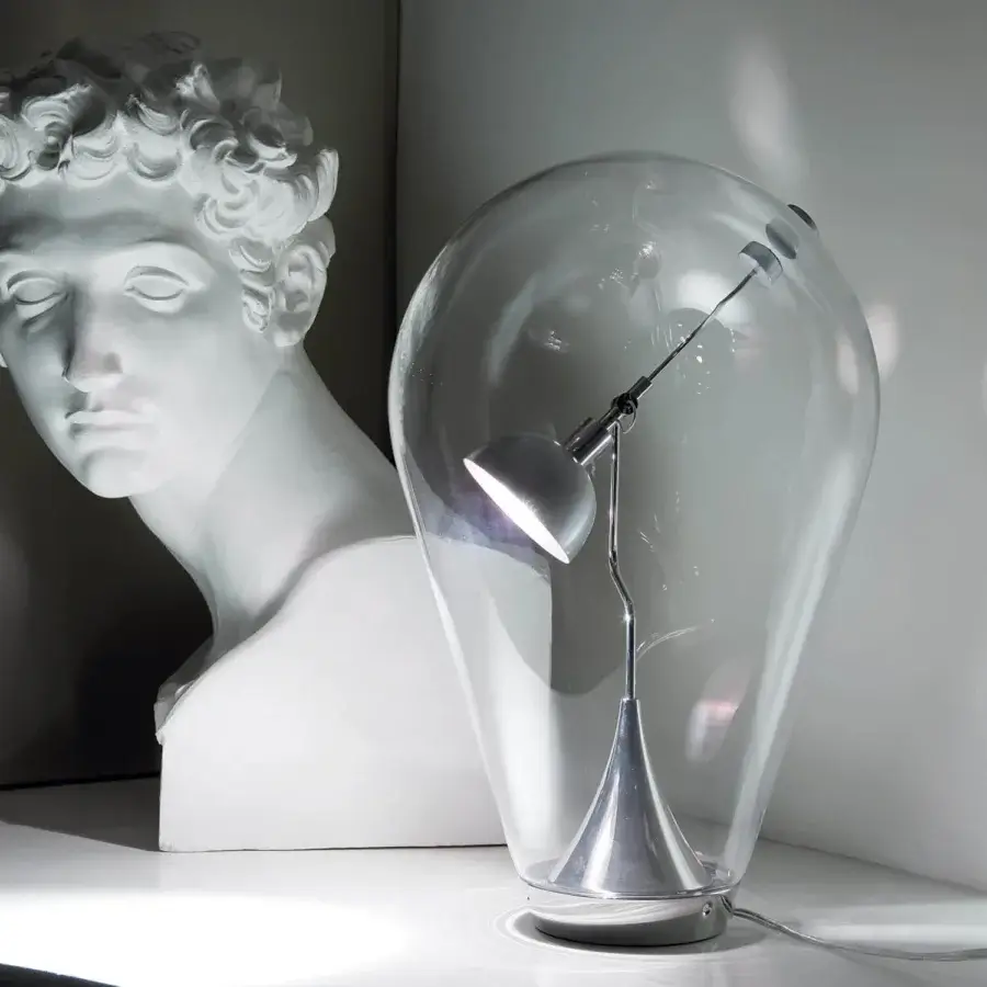 Distinctive Lodes Blow table lamp with clear blown glass enclosure and metallic spotlight head supported by a curved arm
