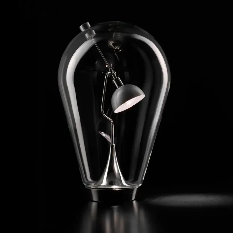 Superior Lodes Blow table lamp with a clear elongated blown glass enclosure and adjustable dark metallic arm