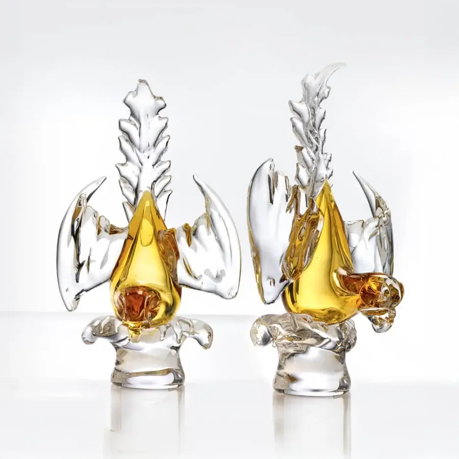 Glass parrot sculptures by Duccio Di Segna, clear glass with amber accents, stylized design featuring curved crests and textured wings.
