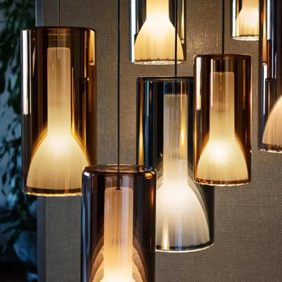 Captivating Penta Lit suspension lamp with cylindrical amber-toned glass revealing vertically ridged inner illumination and glossy finish