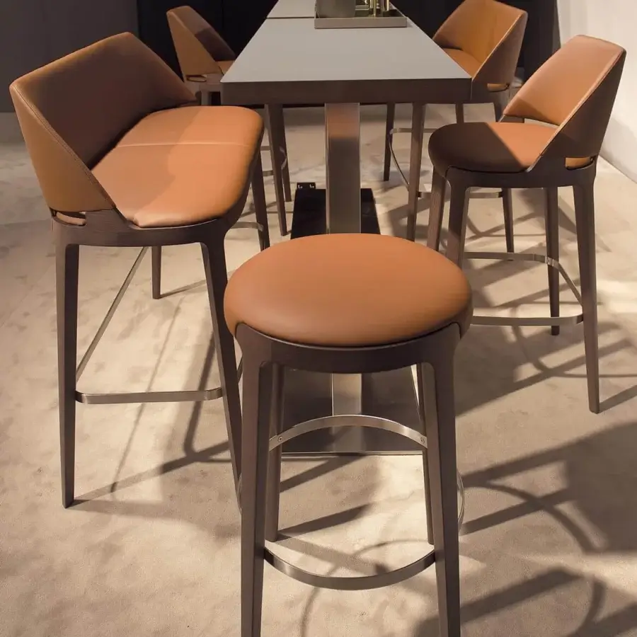 Distinguished Potocco Velis stool with comfortable brown leather and a solid Canaletto walnut frame built with a sleek metal footrest