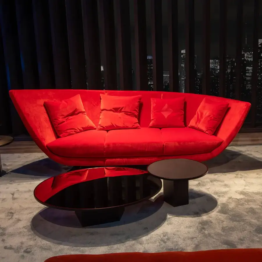 Distinguished Joker Home Collection sofa with uniquely curved silhouette upholstered in saturated red velvet fabric