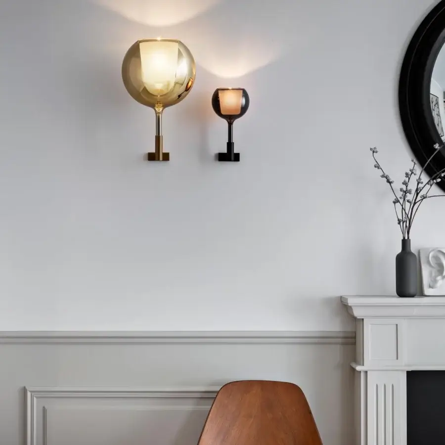 Distinguished Penta Glo wall lamp with gold metal structure and mirrored glass outer shade emitting a warm glow