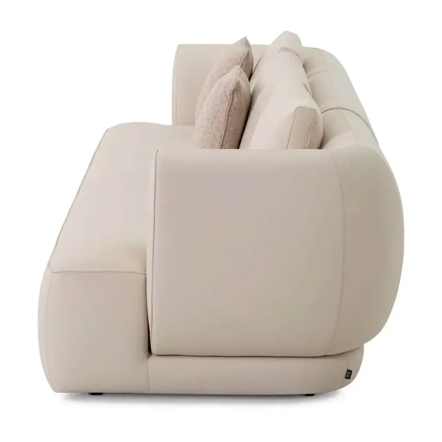 Superior Sicis Botero sofa with a low wide silhouette upholstered in smooth matte light beige fabric and dark base detail