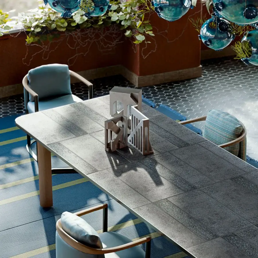 Distinguished Giorgetti Moorea table with pewter painted stainless steel, solid Teak wood legs and Etna lava stone enriched with emerald glass powder