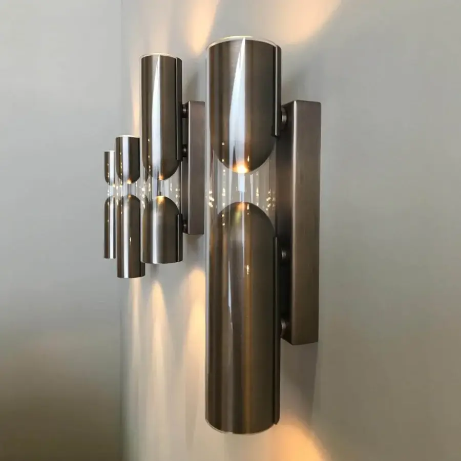 Avant-garde Penta Clash wall lamp uniting transparent glass with a brushed bronze inner structure and metal
