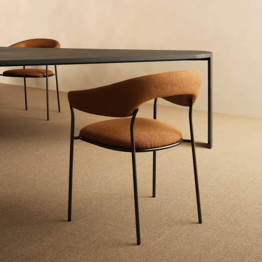 Superior MDF Italia Archie armchair with a gently curved form upholstered in warm orange-brown textile and sleek matte black metal legs