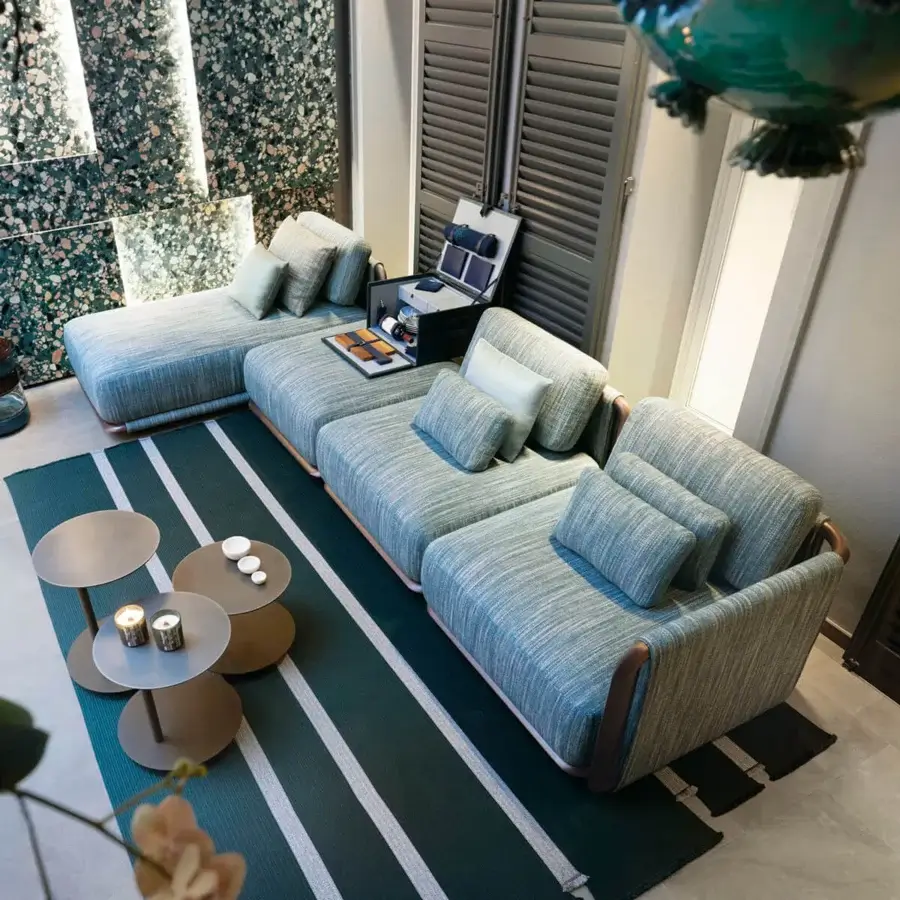 Elegant Giorgetti Moorea sectional with pewter stainless steel frame and muted blue-grey woven fabric upholstery accented with throw pillows