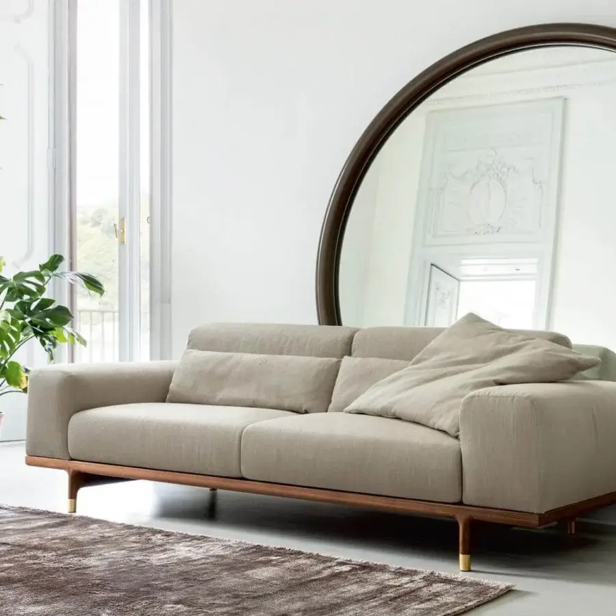 Elegant Porada Argo sofa with light beige textile upholstery and solid Canaletto walnut crafted with Brushed Brass feet
