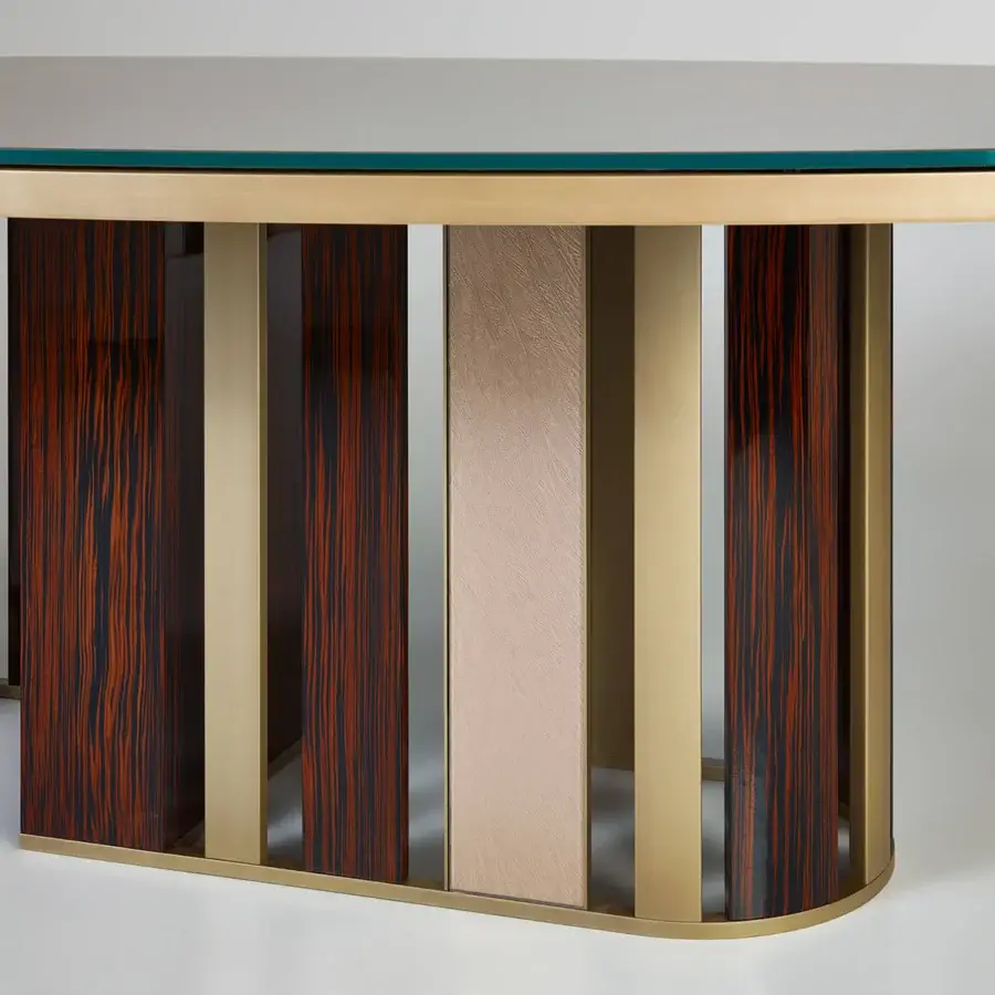 Distinguished Sicis Koro table with oval glass top and dynamic framework built in ebony and gold-toned metal with striped wood base