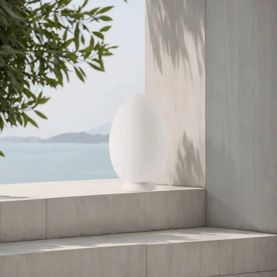Elegant FontanaArte Uovo portable lamp crafted in white satin blown glass emitting uniform light as a light sculpture