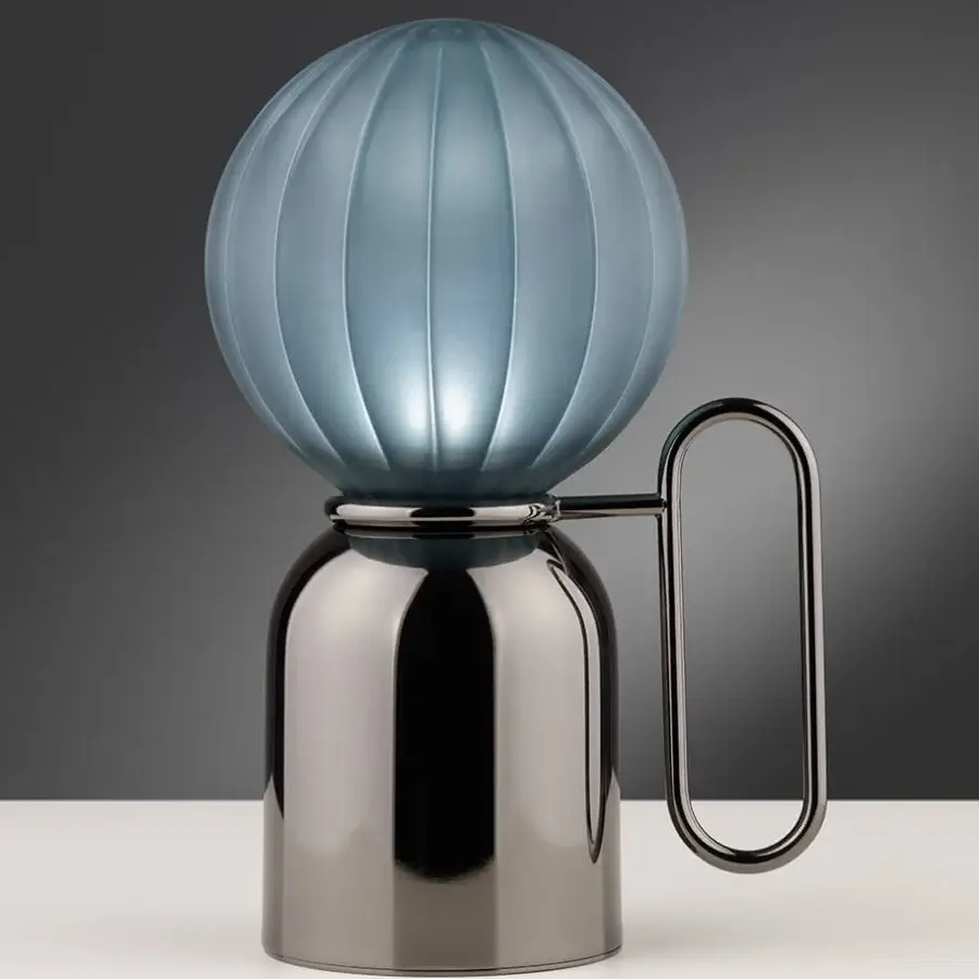Distinguished Euroluce Atlas table lamp in pale blue vertically ribbed glass with a dark reflective metal base and curved handle