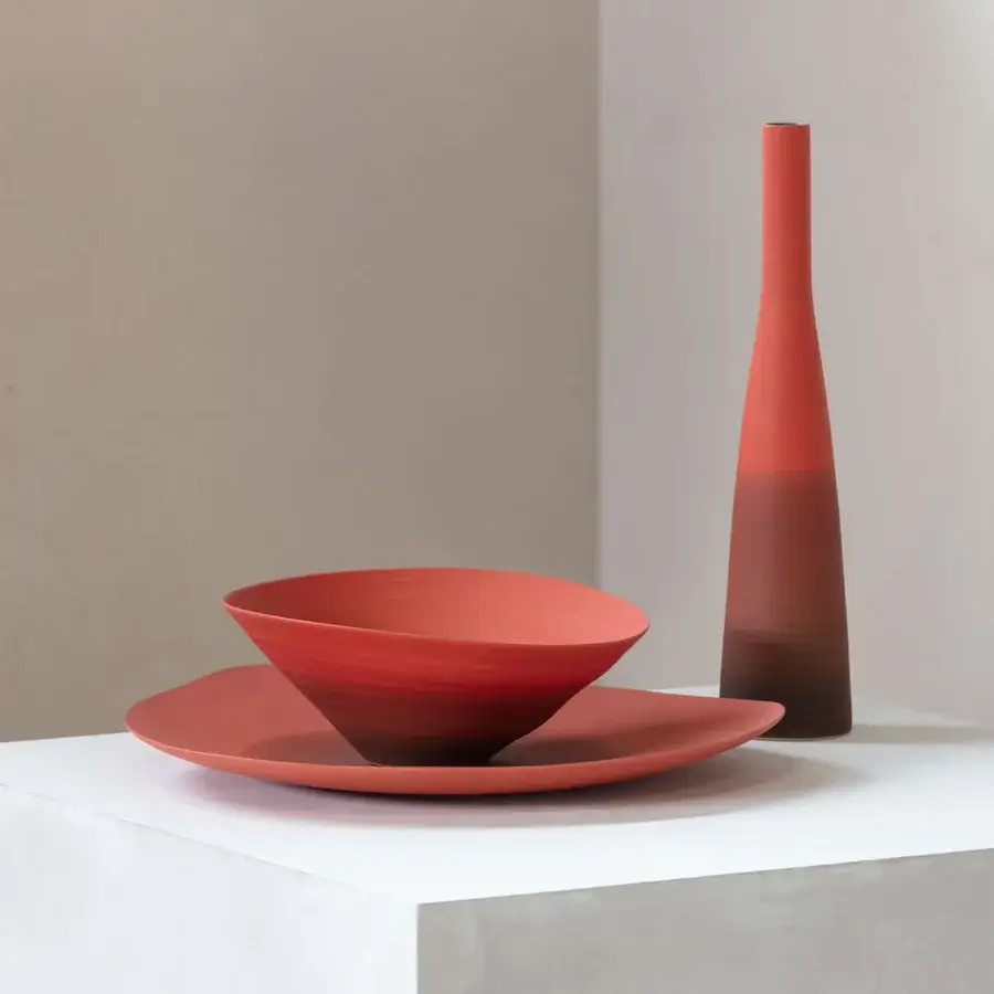 Distinguished Rina Menardi Solo vase crafted in baked clay with a matte finish displaying reddish-brown gradient tones throughout its conical form