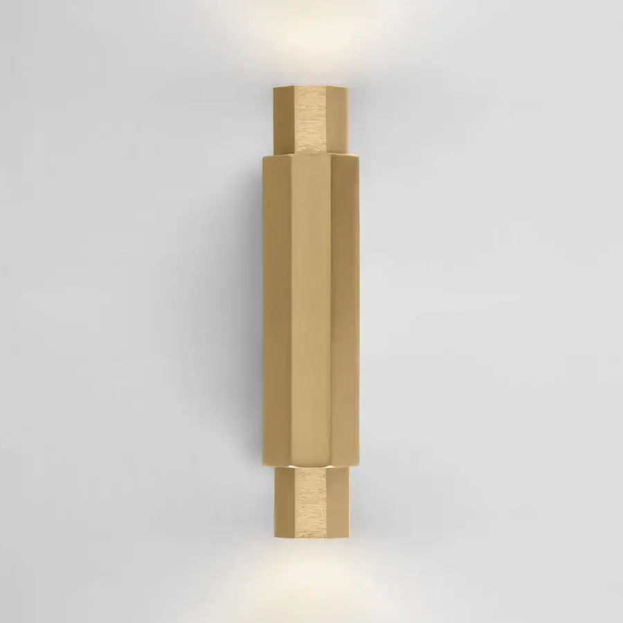 Distinguished Euroluce Castel wall lamp crafted in metal with satin finish, presenting a modern, vertically-oriented form and warm gold tone