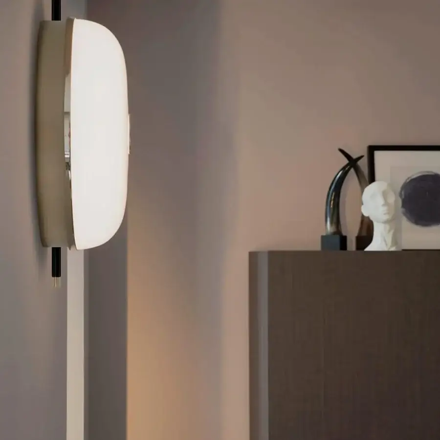 Elegant Sicis Amaretto wall lamp crafted in metal with polished black nickel and polished champagne finishes supporting milky white blown glass