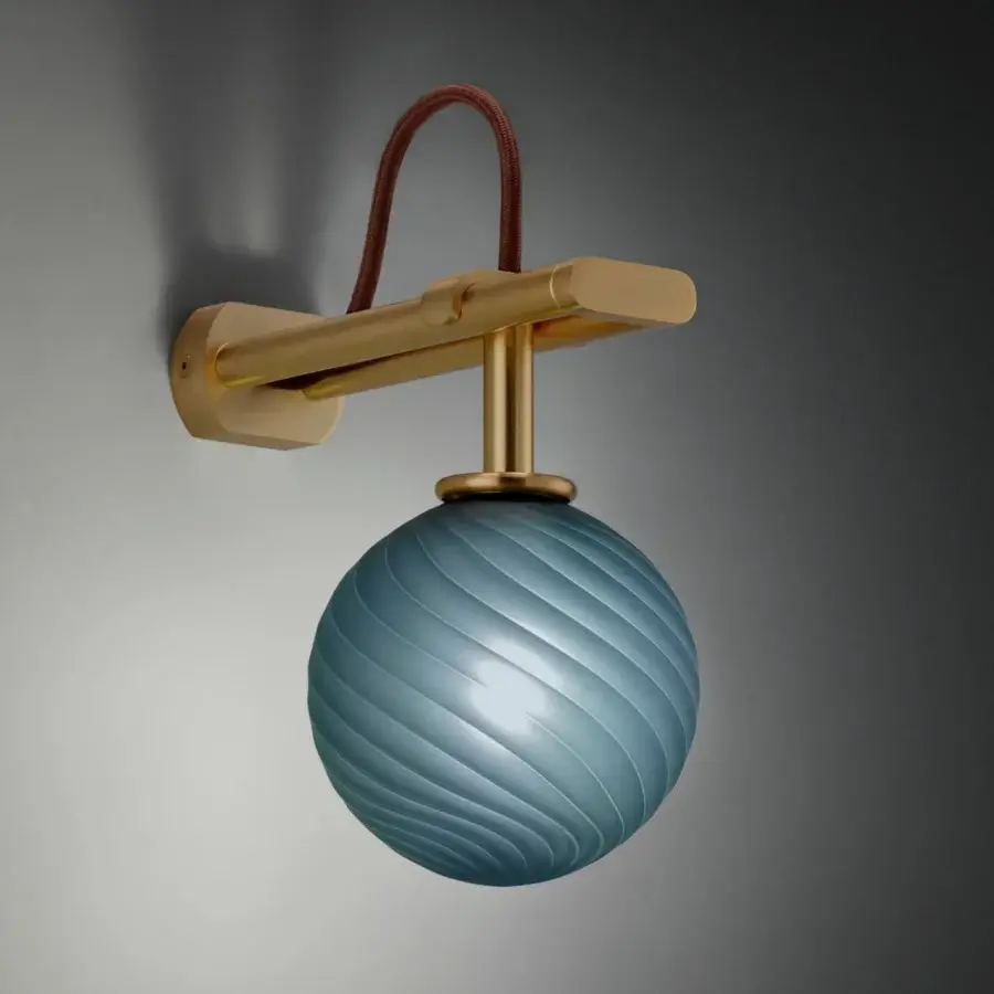 Wall lamp, brass and glass, horizontal arm with light blue spherical shade featuring ridged texture, brown cord, gradient gray backdrop.