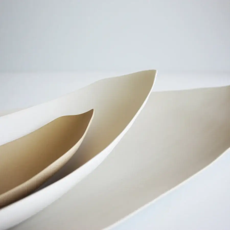 Distinguished Rina Menardi Barchette centerpiece crafted in baked clay with flowing lines and a subtle white to tan gradient