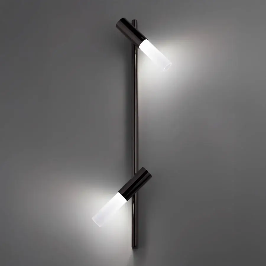 Wall lamp, dark bronze finish, slender vertical rod with two adjustable cylindrical heads and bright white oval light sources.