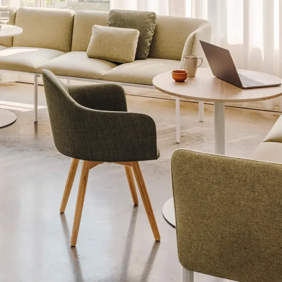 Lavish Lapalma Edit armchair with sculpted shell upholstered in muted olive green fabric and gently splayed solid ash legs with satin finish