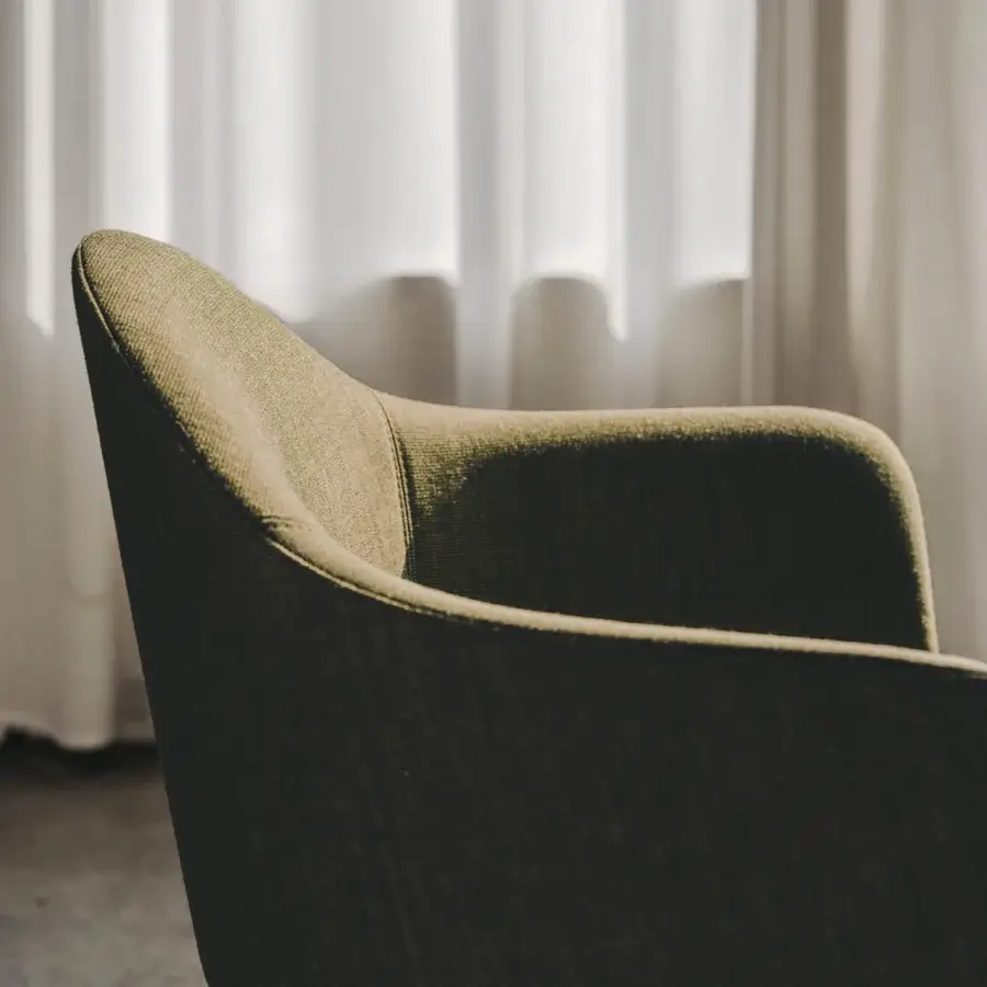 Distinguished Lapalma Edit armchair with organically curved form upholstered in muted olive green textile and solid ash wood base with varnished finish