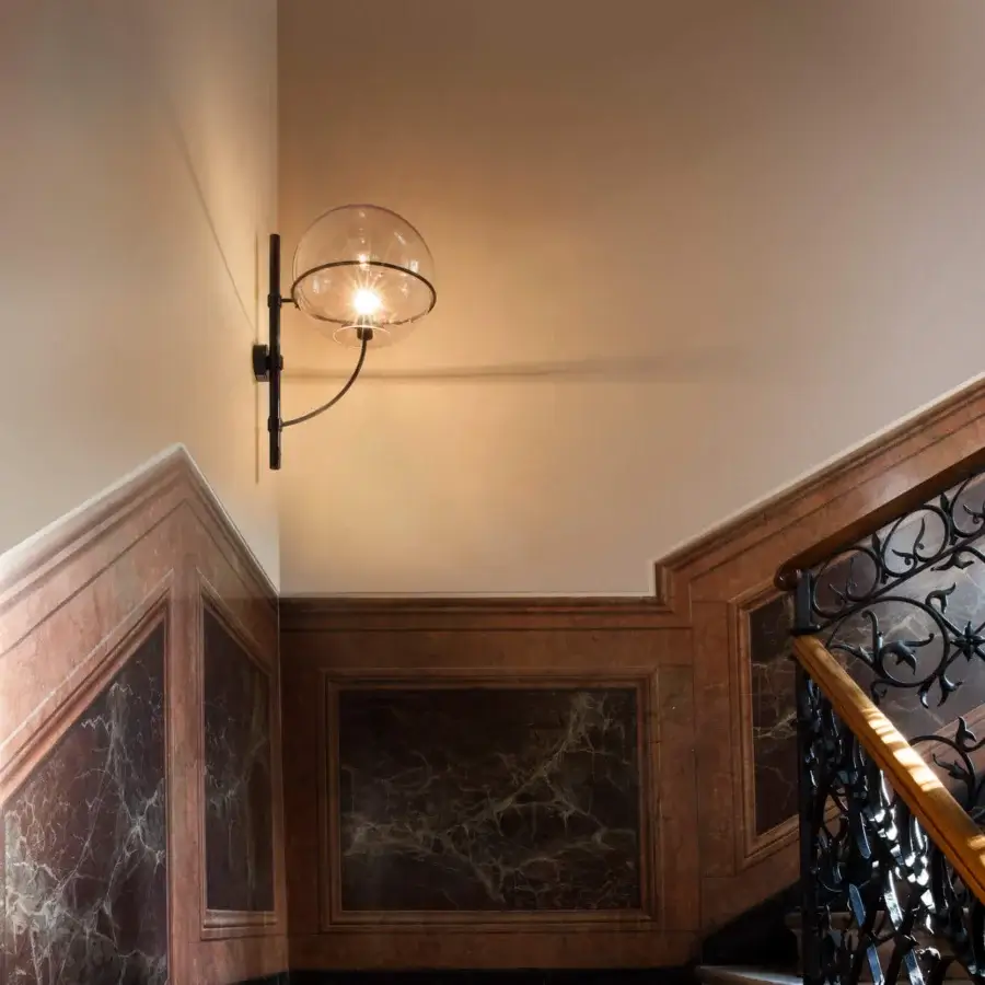 Exceptional Oluce Lyndon wall lamp with a matte black metal arm and transparent polycarbonate spheres creating a single luminous globe