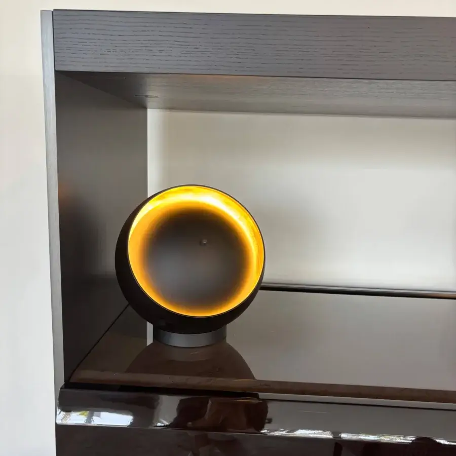 Distinguished Oluce Eva lamp crafted in dark matte metal with a delicate gold-leaf interior and unique circular opening