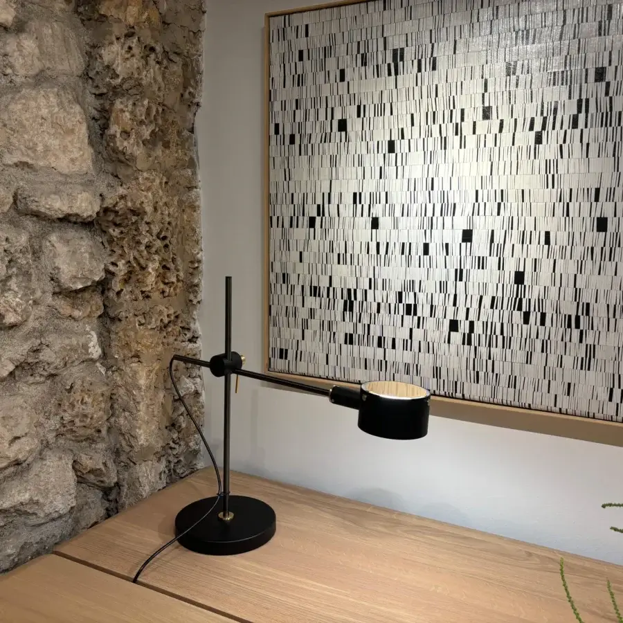 Distinguished Oluce G.O table lamp crafted in matte black metal with an adjustable extending arm