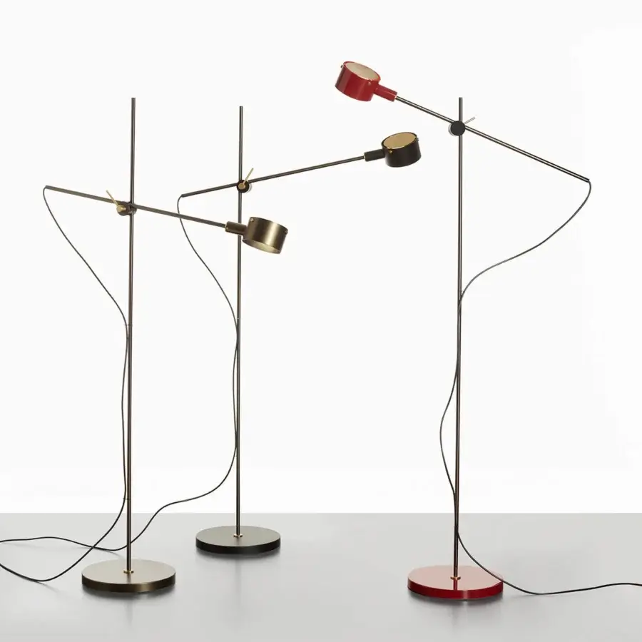 Distinguished Oluce G.O. floor lamp with a polished brass-toned base and dark gray lampshade exhibiting a subtly brushed metallic finish