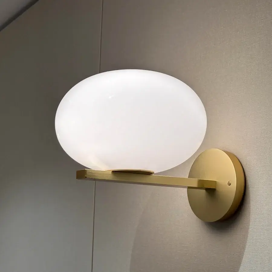 Distinguished Oluce Alba wall lamp crafted in Italy with opaque spherical glass and satin gold-toned metal arm