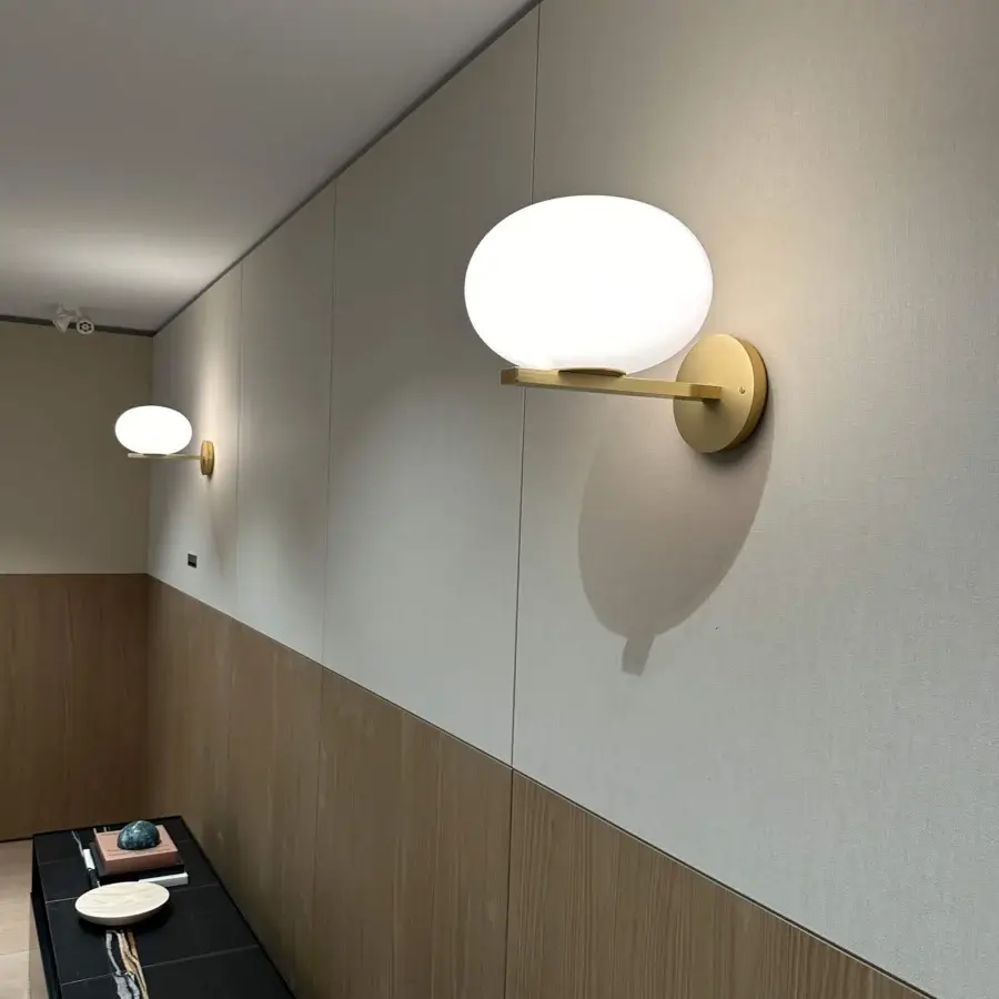 Exceptional Oluce Alba wall lamp crafted in Italy with brassy golden metal and frosted glass globe with satin finish