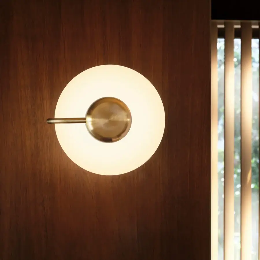Elegant Kundalini Tratto wall lamp crafted in polished satin metal and opal glass with a warm golden hue