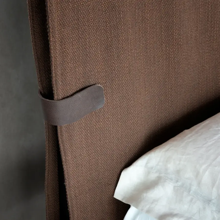 Elegant Presotto Dress Code bed with warm brown woven fabric and dark brown leather accenting a minimalist headboard