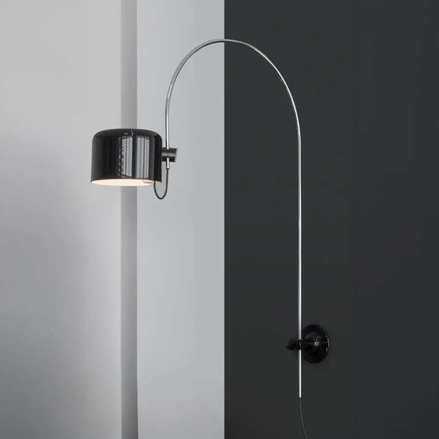 Superior Oluce Coupé wall lamp delivering directed light with a glossy silver-tone metal arm and black cylindrical lampshade with horizontal ridges
